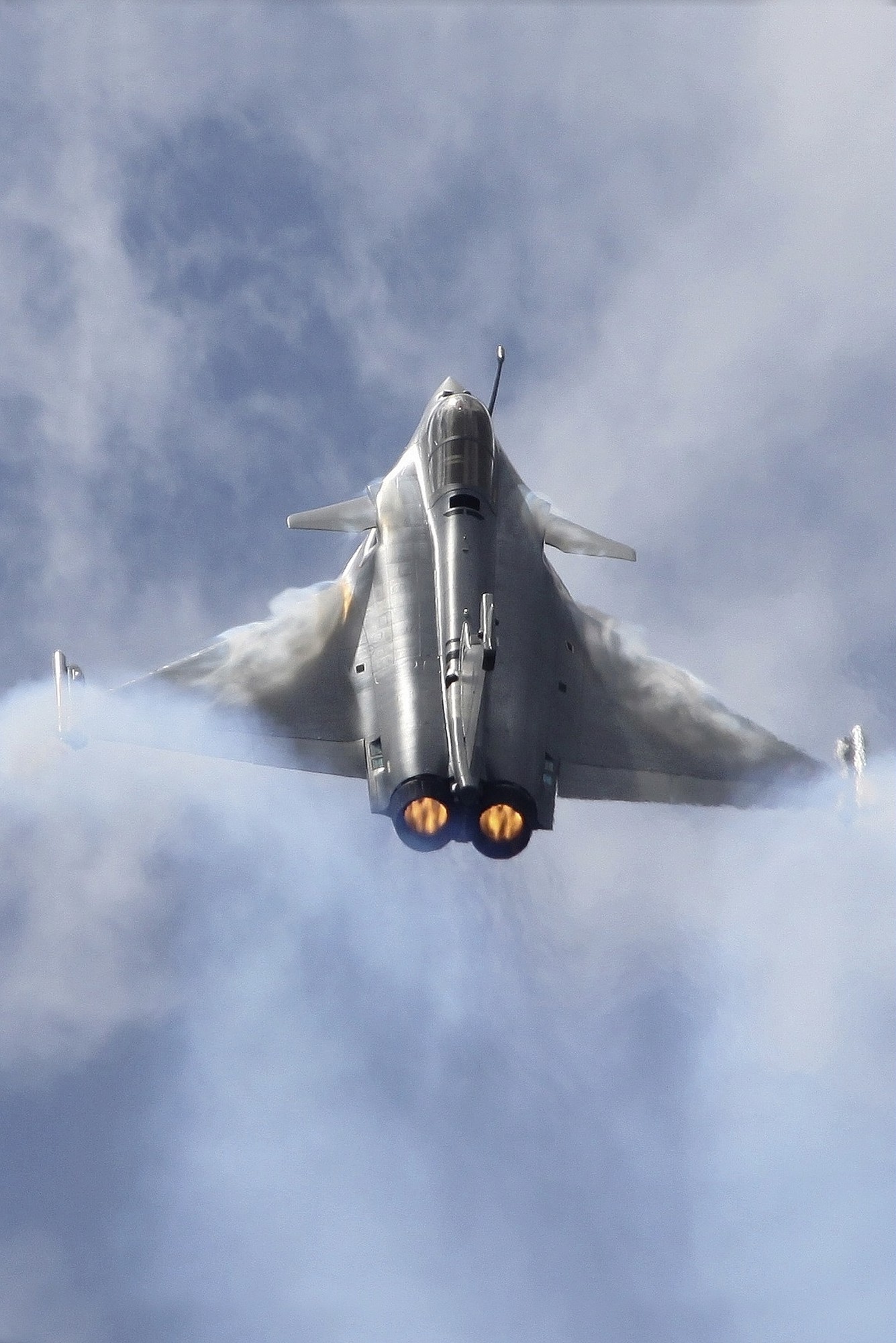 Caças Rafale em voo com pós-combustão, executando manobra de subida