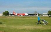 Pessoas jogam golfe no meio das pistas de aeroporto na Tailândia 